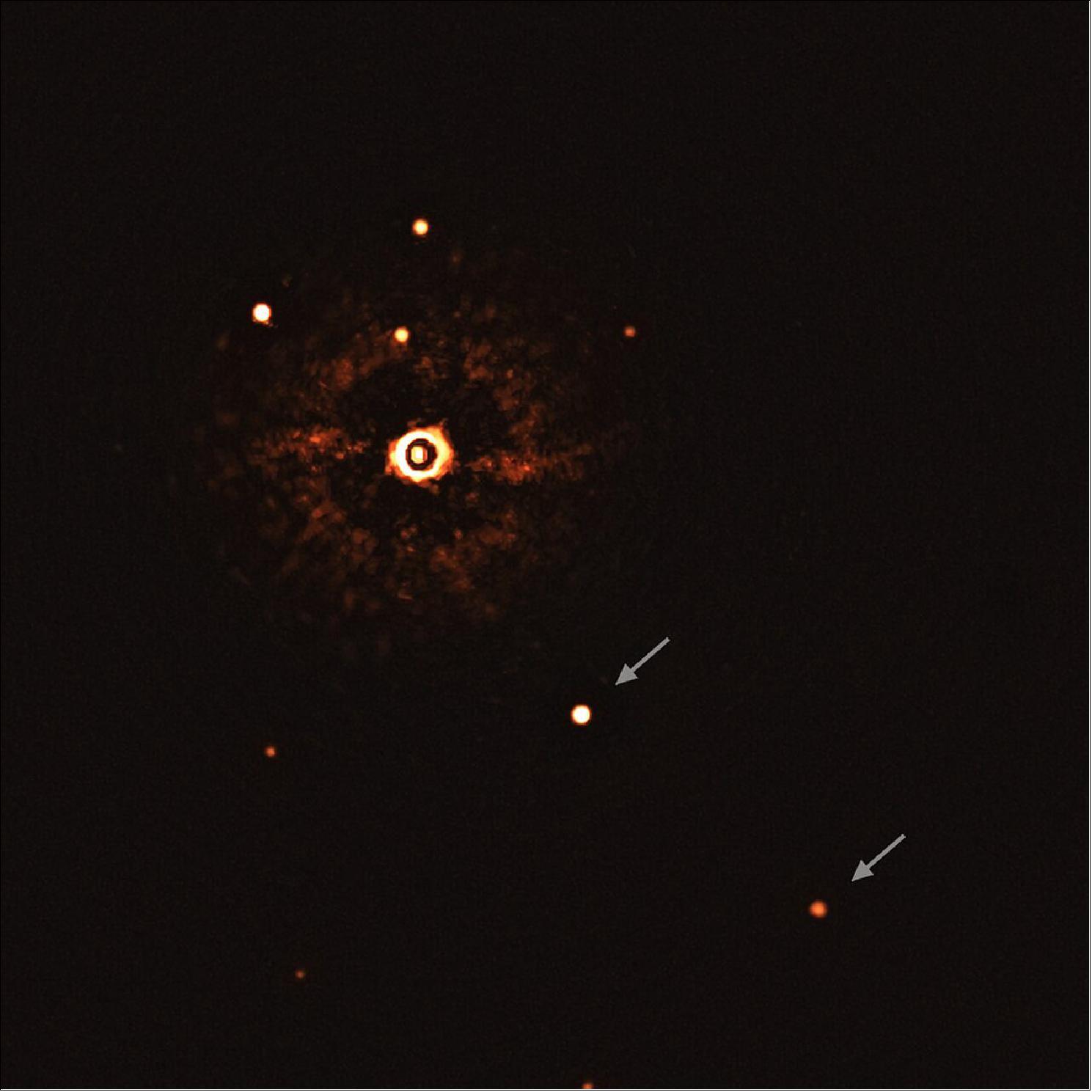 Figure 33: This image, captured by the SPHERE instrument on ESO’s Very Large Telescope, shows the star TYC 8998-760-1 accompanied by two giant exoplanets, TYC 8998-760-1b and TYC 8998-760-1c. This is the first time astronomers have directly observed more than one planet orbiting a star similar to the Sun. The two planets are visible as two bright dots in the center (TYC 8998-760-1b) and bottom right (TYC 8998-760-1c) of the frame. Other bright dots, which are background stars, are visible in the image as well. By taking different images at different times, the team were able to distinguish these planets from the background stars. The image was captured by blocking the light from the young, Sun-like star (top-left of center) using a coronagraph, which allows for the fainter planets to be detected. The bright and dark rings we see on the star’s image are optical artefacts (image credit: ESO/Bohn et al.)