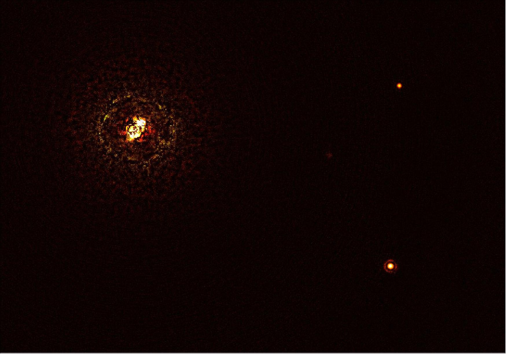 Figure 12: This image shows the most massive planet-hosting star pair to date, b Centauri, and its giant planet b Centauri b. This is the first time astronomers have directly observed a planet orbiting a star pair this massive and hot. - The star pair, which has a total mass of at least six times that of the Sun, is the bright object in the top left corner of the image, the bright and dark rings around it being optical artefacts. The planet, visible as a bright dot in the lower right of the frame, is ten times as massive as Jupiter and orbits the pair at 100 times the distance Jupiter orbits the Sun. The other bright dot in the image (top right) is a background star. By taking different images at different times, astronomers were able to distinguish the planet from the background stars. - The image was captured by the SPHERE instrument on ESO’s Very Large Telescope and using a coronagraph, which blocked the light from the massive star system and allowed astronomers to detect the faint planet (image credit: ESO/Janson et al.)
